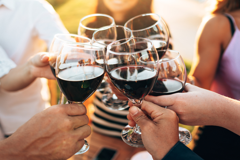 people clink wine glasses together at a festival